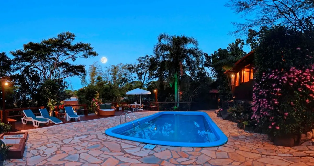 Piscina e área externa da Pousada Rosa ao entardecer