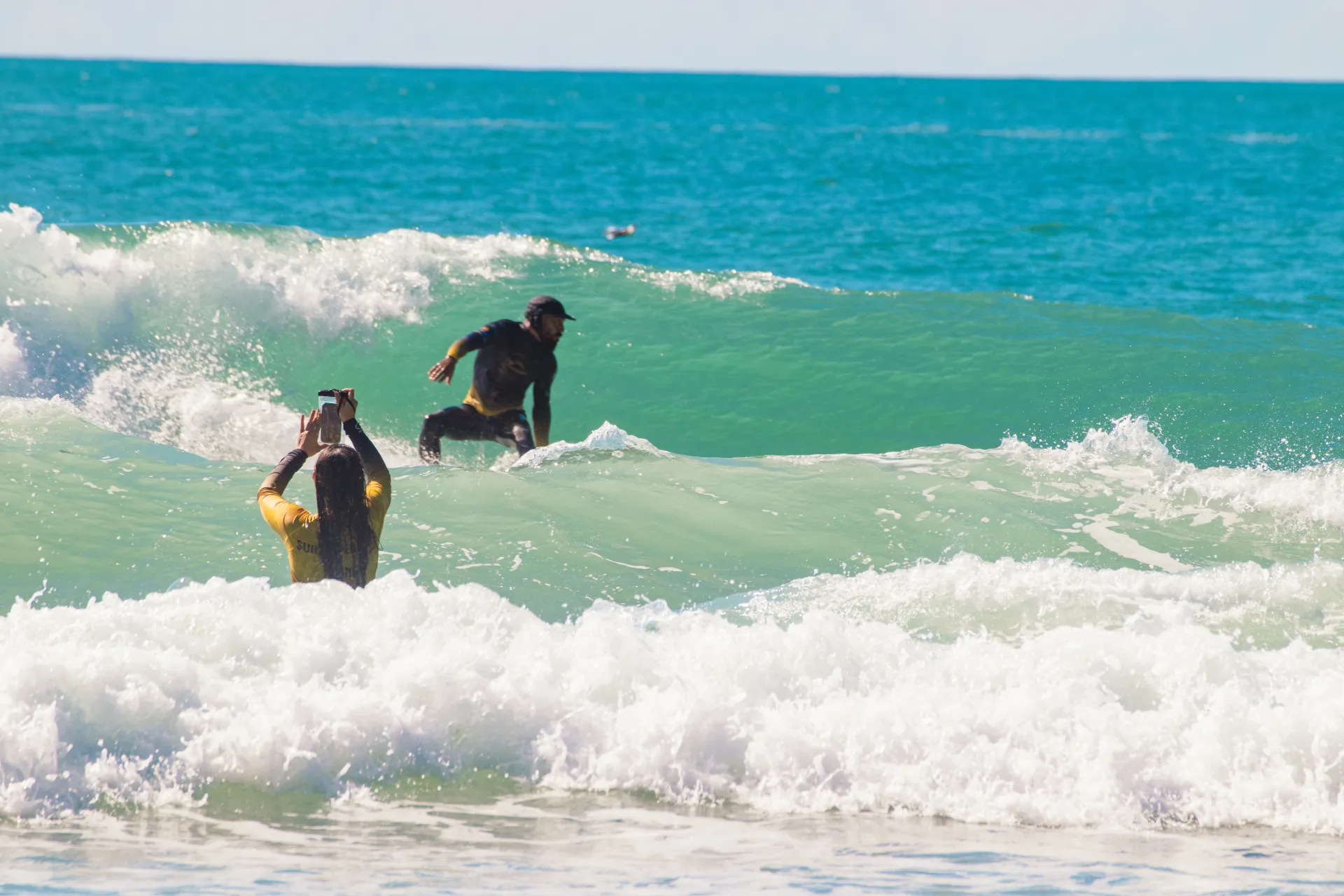 Foto de sessão de surf — aluno Village Summer pegando onda em Florianópolis